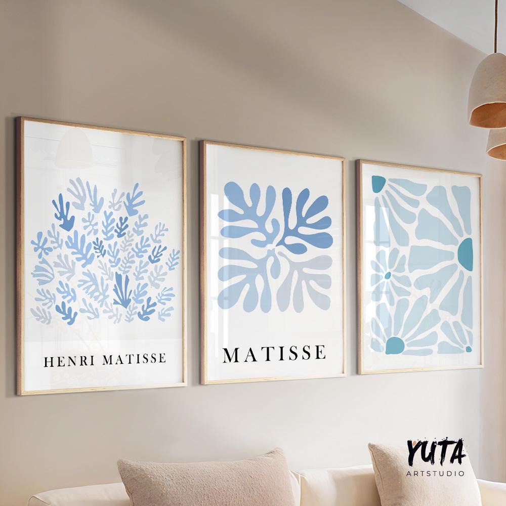 Three mid-century blue Matisse prints in light wood frames arranged above a sofa