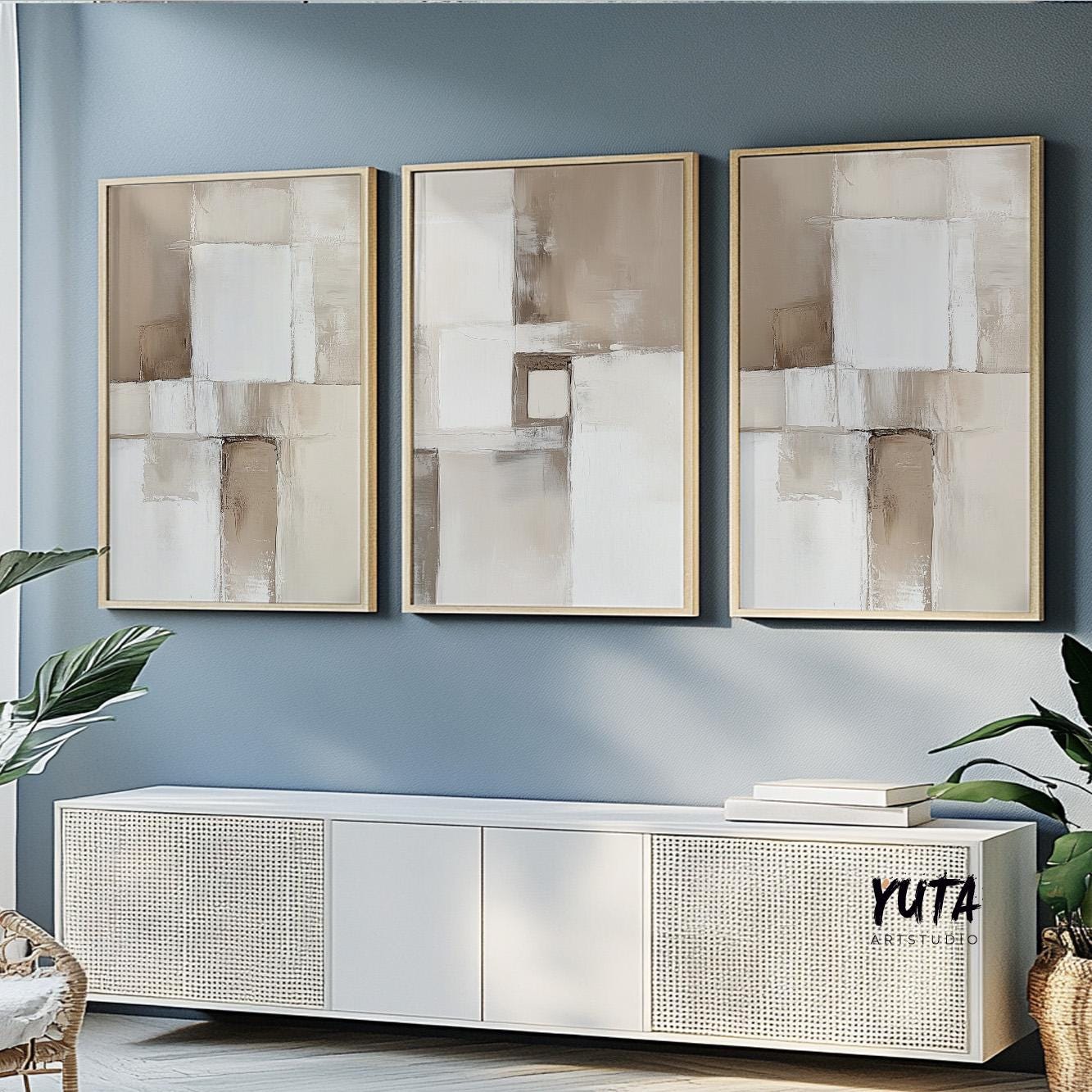 Three neutral abstract brush stroke prints in light wood frames above a modern console