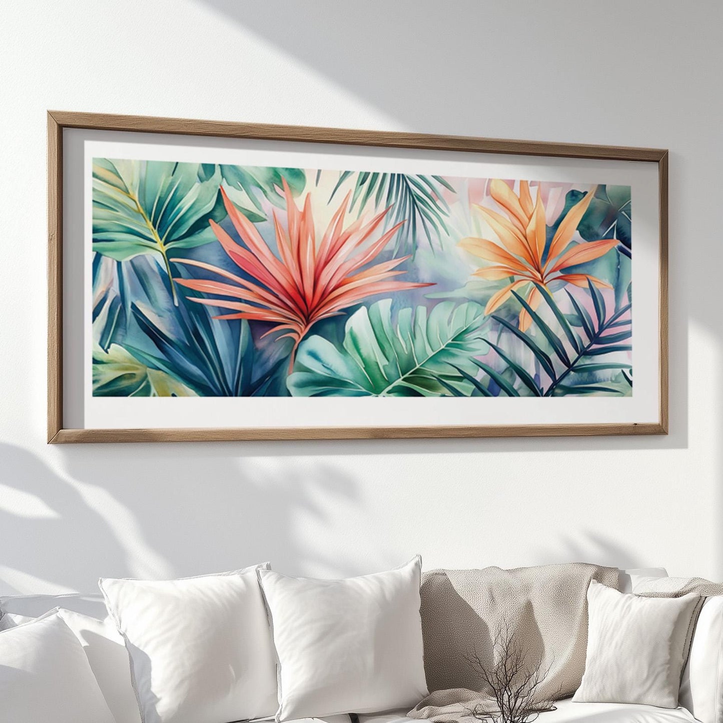 Watercolor tropical leaves artwork in a natural wood frame displayed above a white sofa