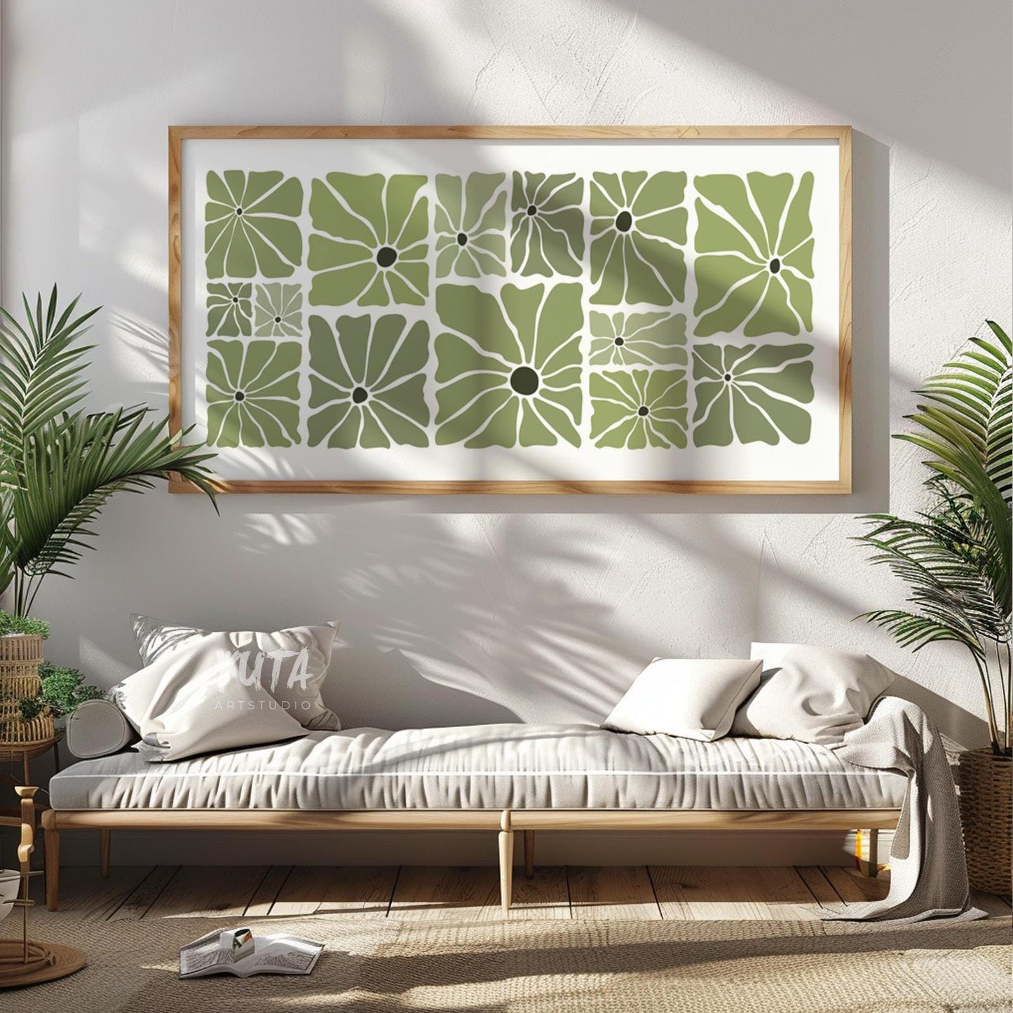 Framed olive green retro floral print styled above a light wood console with plants nearby