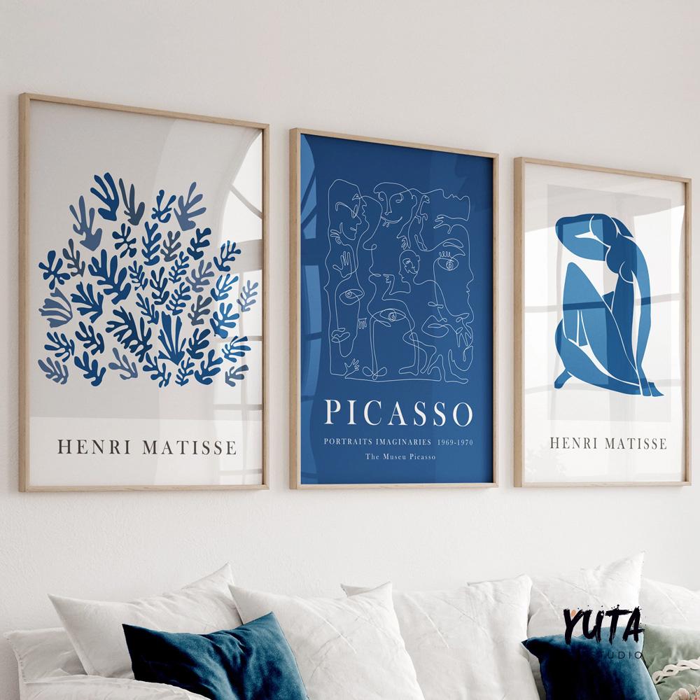 Set of three framed navy blue abstract prints arranged as a gallery wall above a sofa.