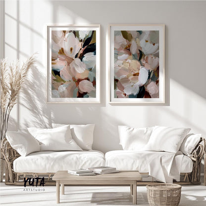 Two abstract floral prints in light wood frames displayed above a neutral sofa set