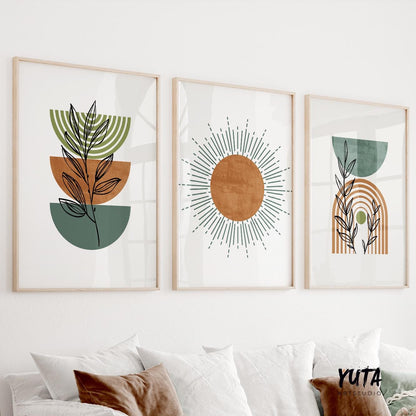 Three framed boho prints with modern botanical and sunburst motifs above pillows for scale