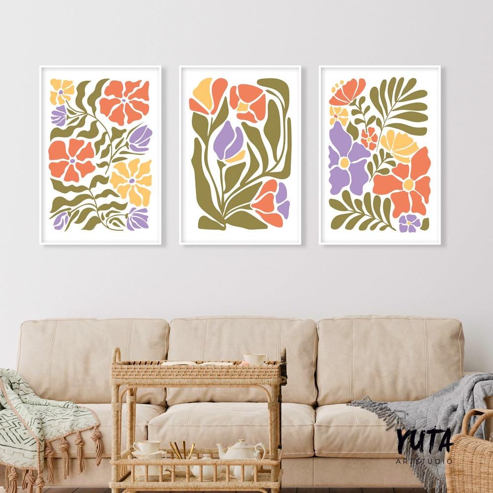 Matisse-inspired floral trio in white frames arranged above a neutral sofa