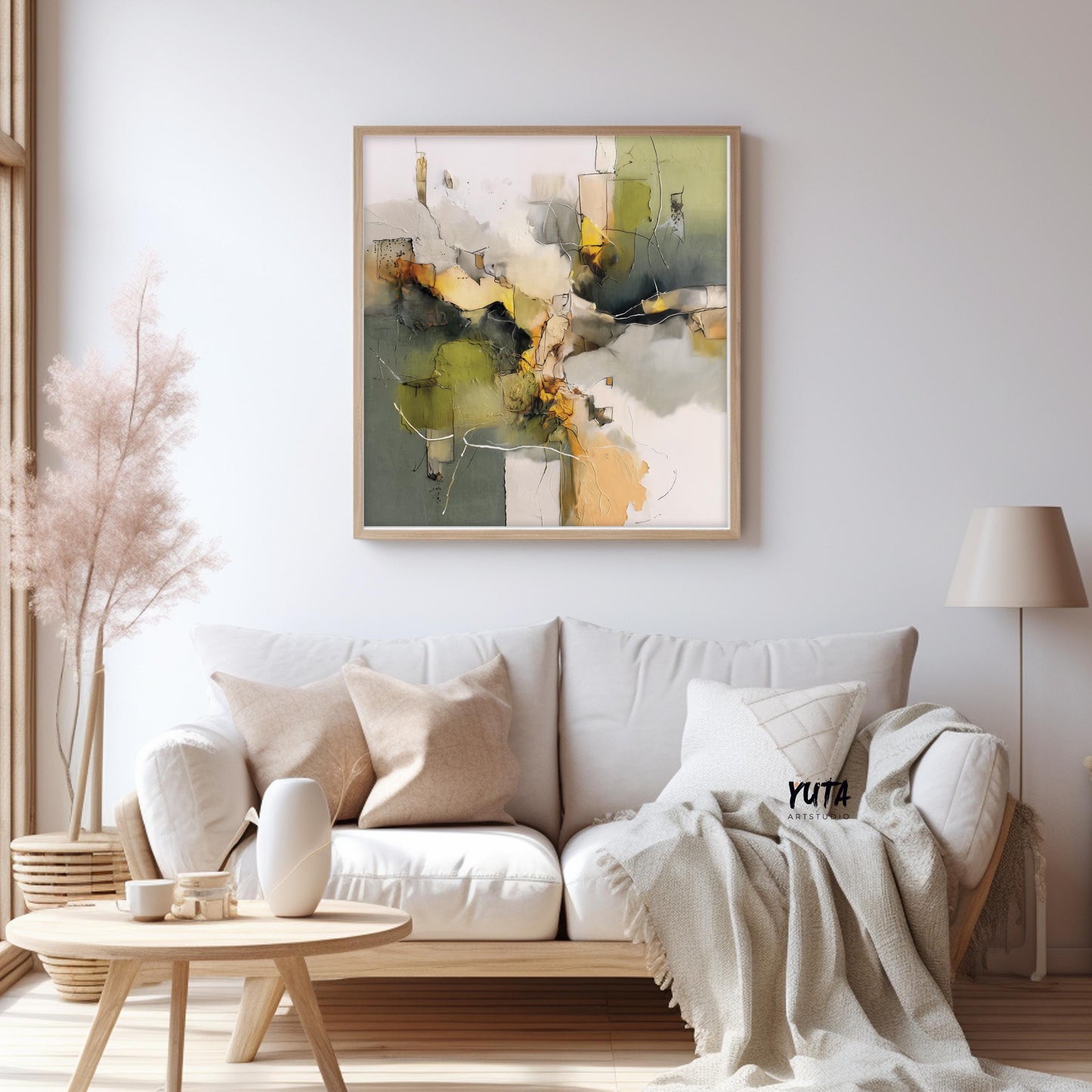 Square abstract painting in olive green and beige displayed in a light wood frame above a sofa
