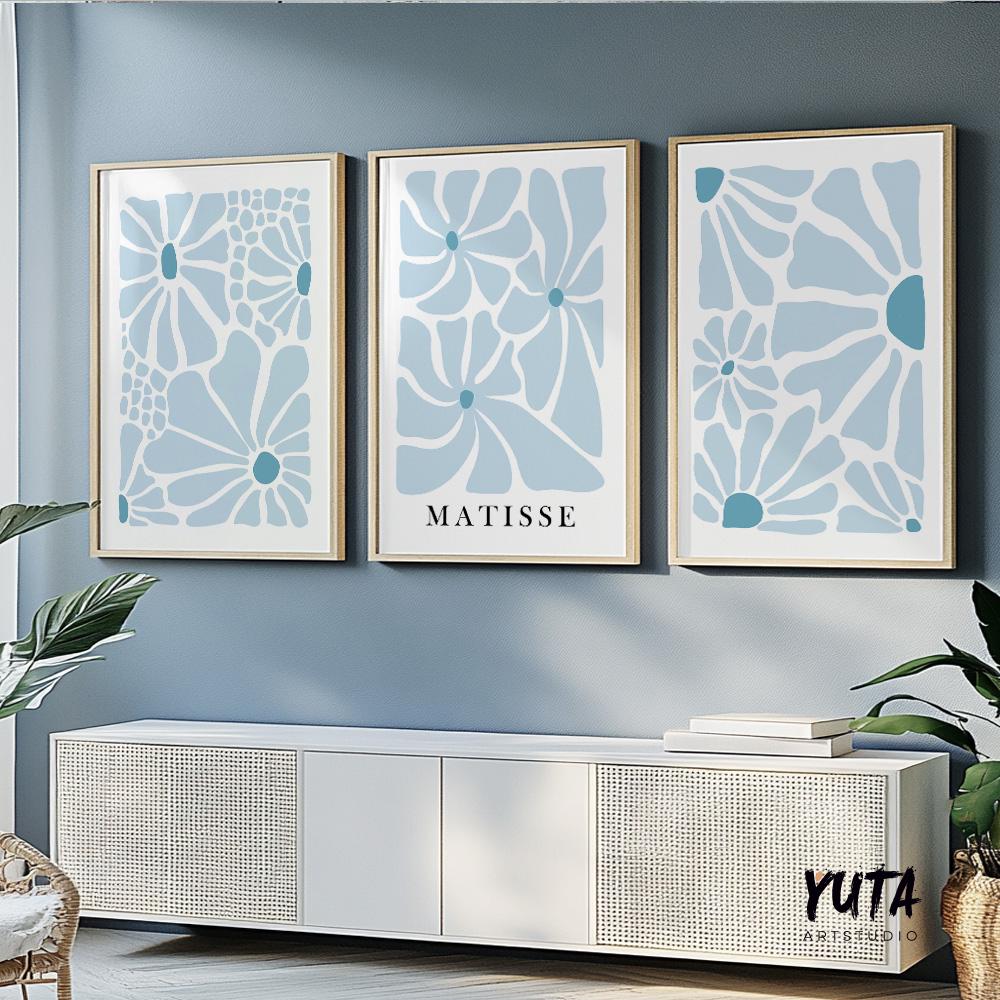 Trio of framed abstract botanical prints in soft blue tones arranged above a white console