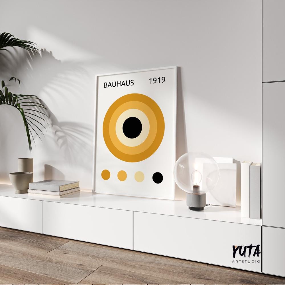 Geometric Bauhaus poster with mustard yellow circles framed and leaning on a white cabinet
