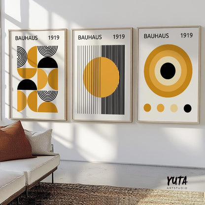 Trio of framed Bauhaus-style geometric prints in mustard and black above a modern console
