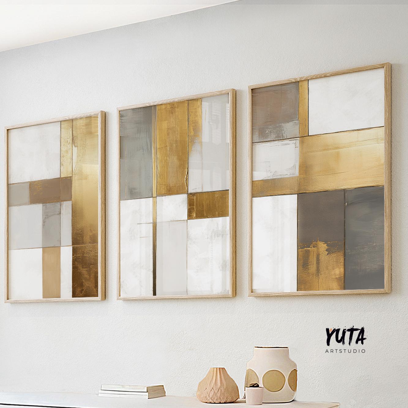 Three-panel abstract artwork in gold, beige, and white tones, framed and lit by daylight