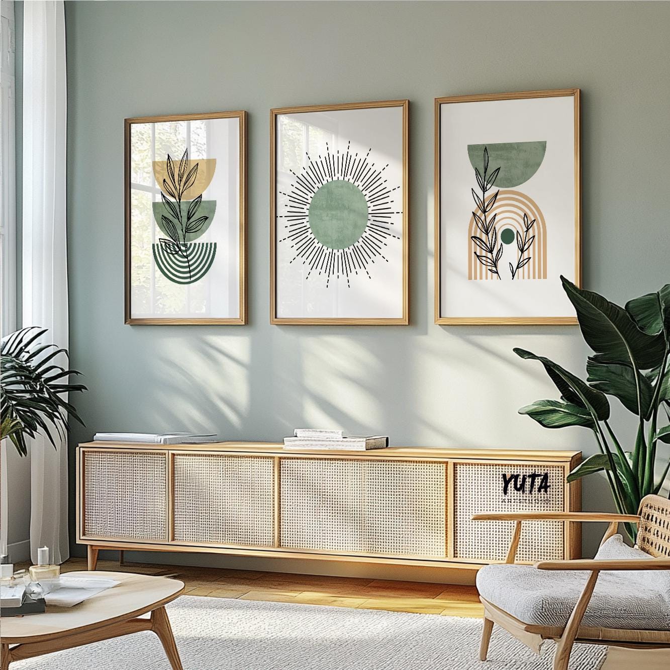 Botanical and abstract sage green prints in natural wood frames above a woven sideboard