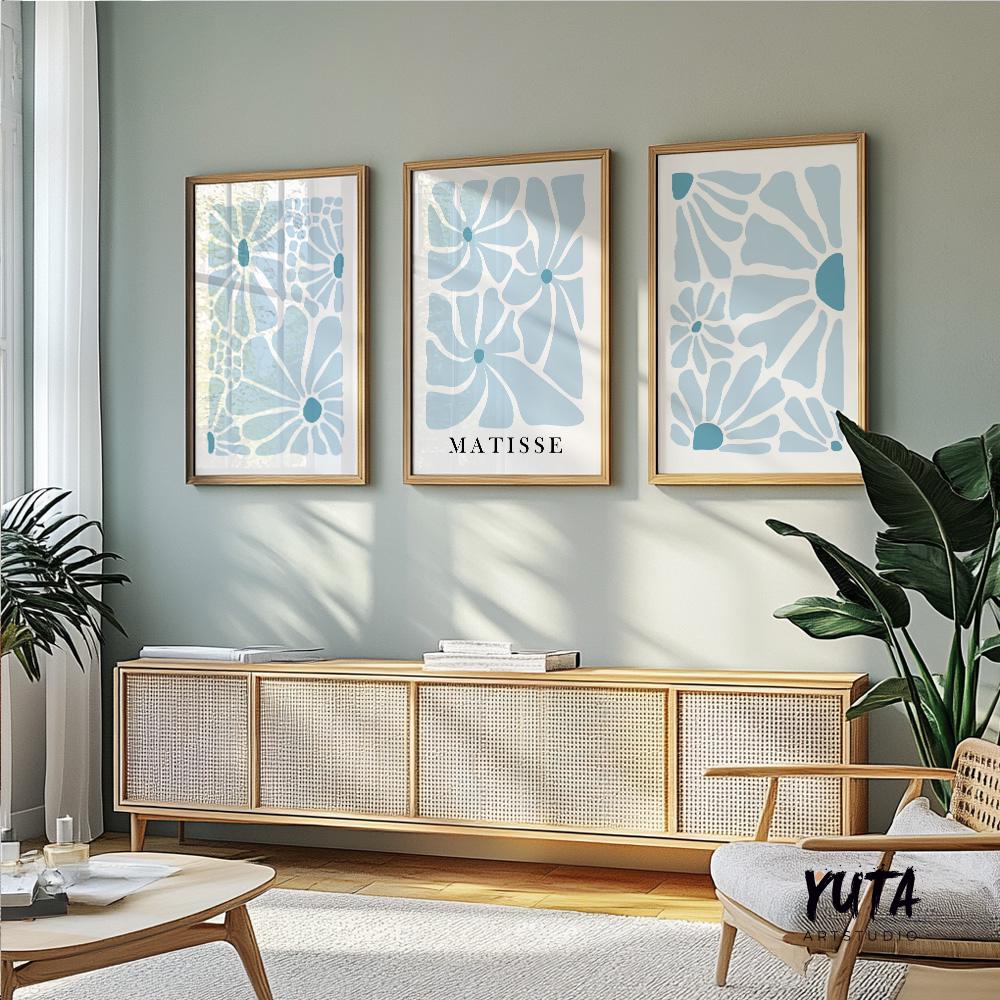 Three framed blue abstract floral prints in various sizes displayed above a sideboard.