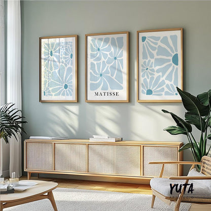 Three framed blue abstract floral prints in various sizes displayed above a sideboard.