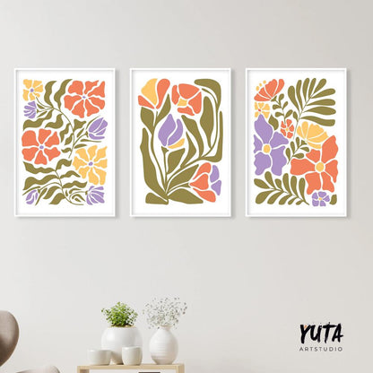 Three framed Matisse-inspired floral prints arranged above a light wood console with ceramics