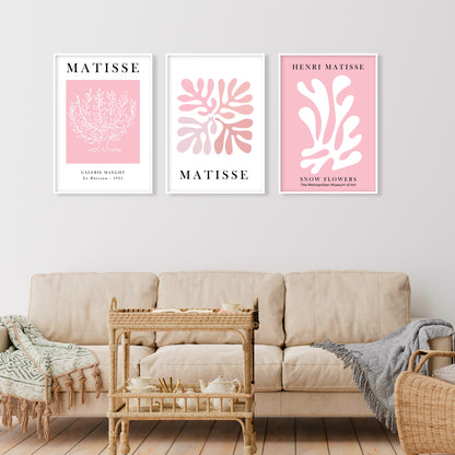 Three pastel pink Matisse prints in white frames hung above a neutral sofa arrangement