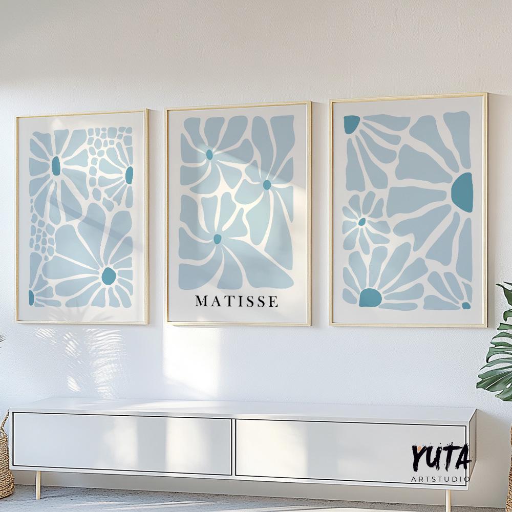 Abstract blue floral prints in minimalist style, framed as a trio above a white cabinet
