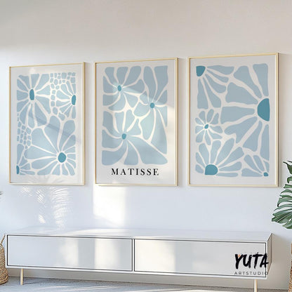 Abstract blue floral prints in minimalist style, framed as a trio above a white cabinet