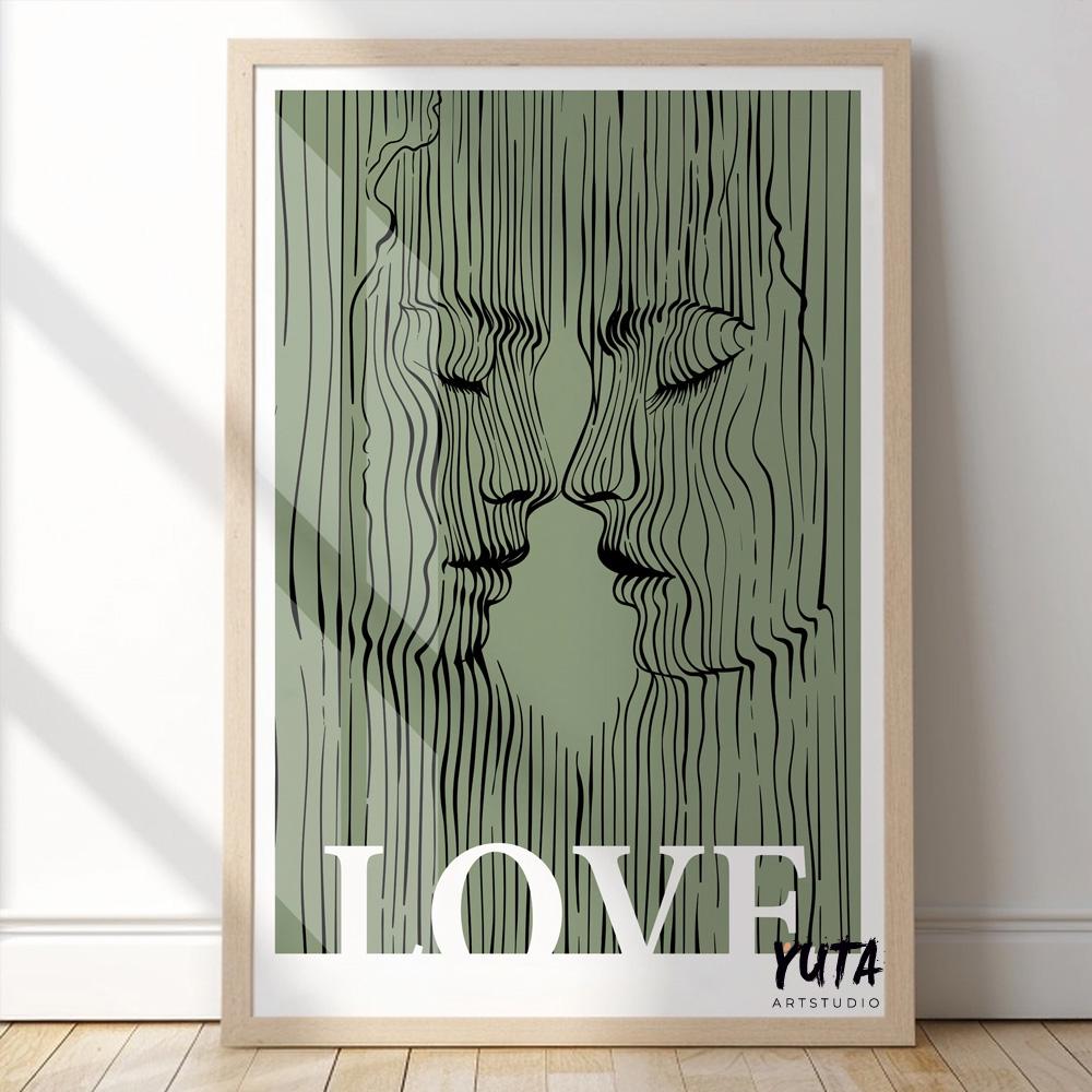 Framed abstract lovers print with black line faces on sage green, lit by window sunlight.