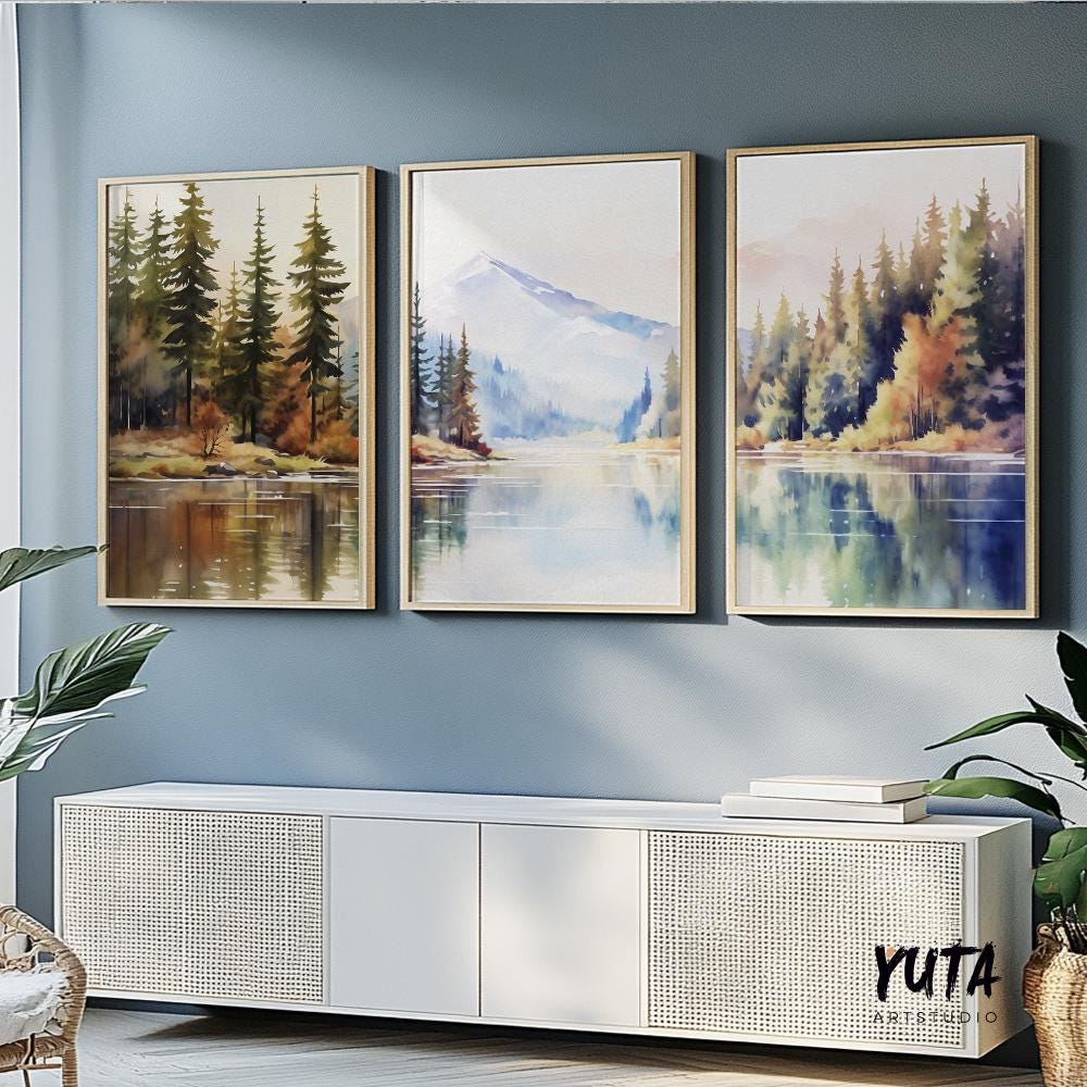 Mountain lake watercolor prints arranged as a gallery wall above a neutral beige wall in a contemporary living space