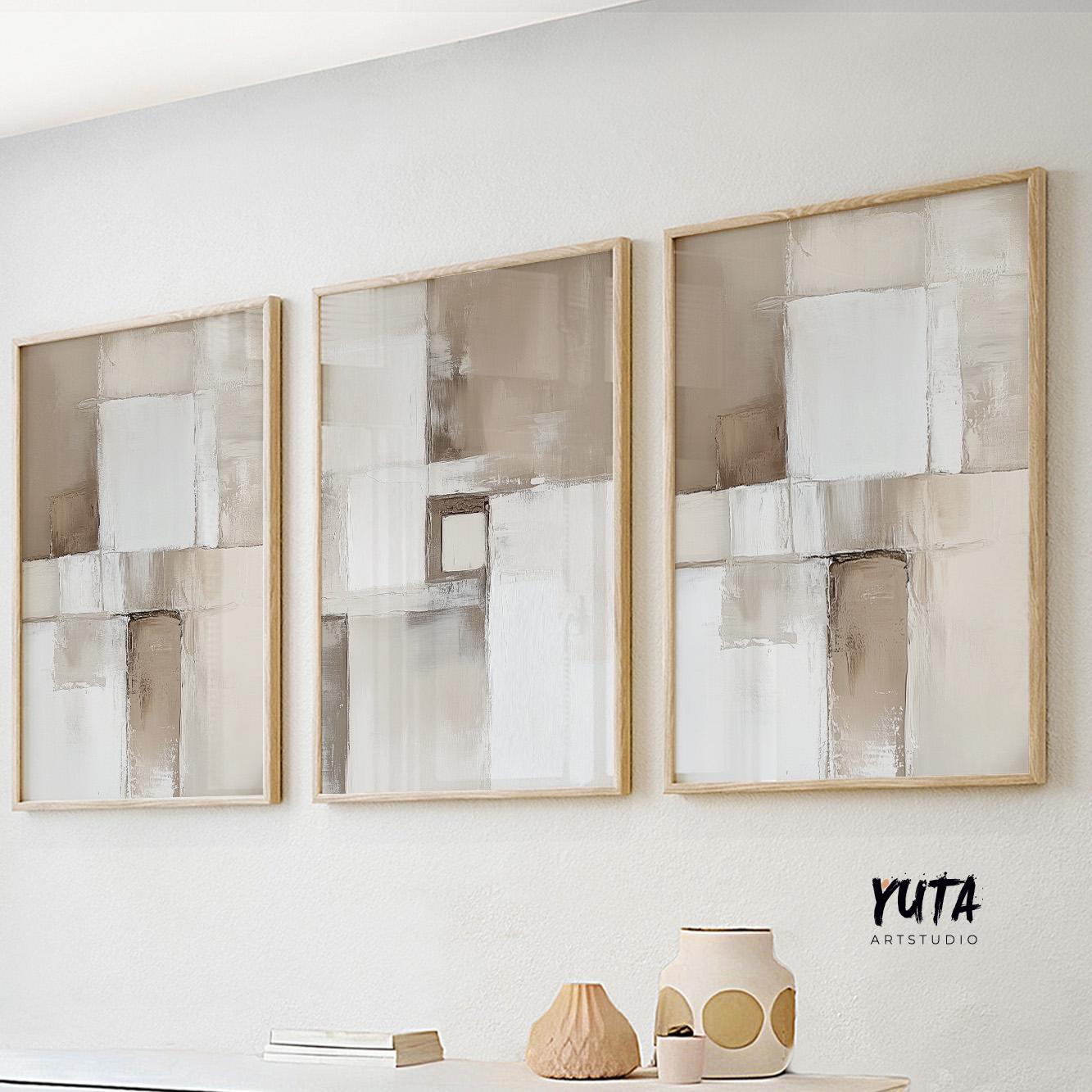 Neutral abstract triptych with beige and white tones in light wood frames above a white console