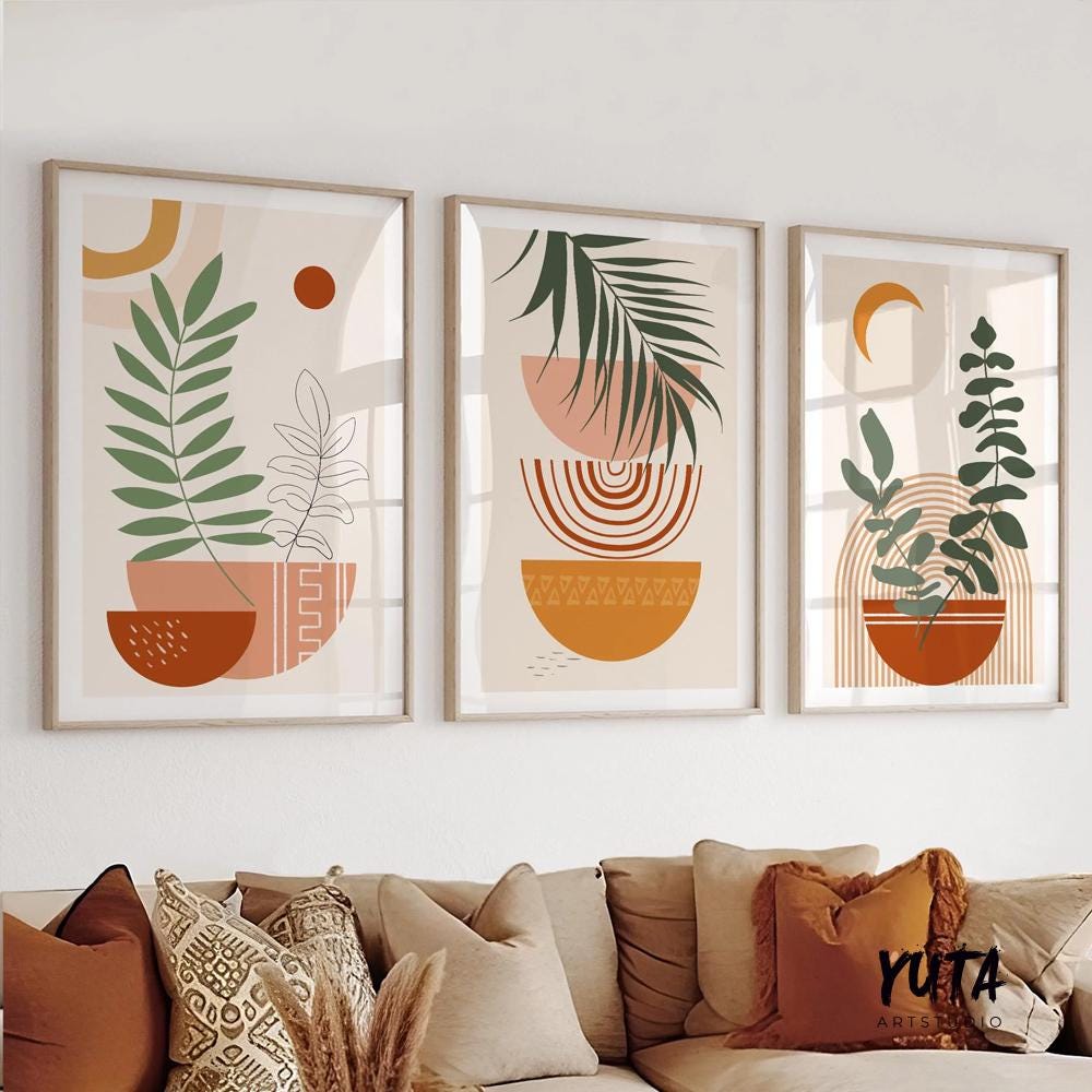 Three framed botanical abstract prints in terracotta tones displayed above a beige sofa