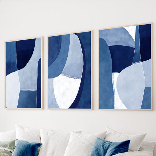 Blue abstract wall art set of 3 featuring navy, denim blue, light blue and white organic geometric shapes.