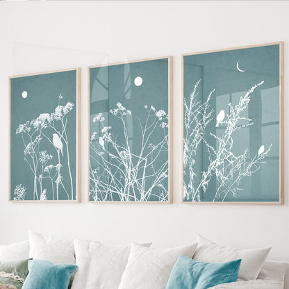 Blue botanical wall art set of 3 featuring wildflowers and perched birds on dusty blue backgrounds