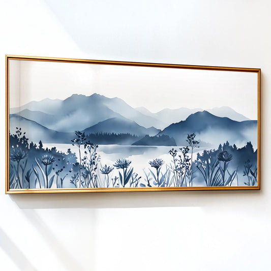 Navy blue mountain landscape print with wildflowers in a gold frame on a white wall