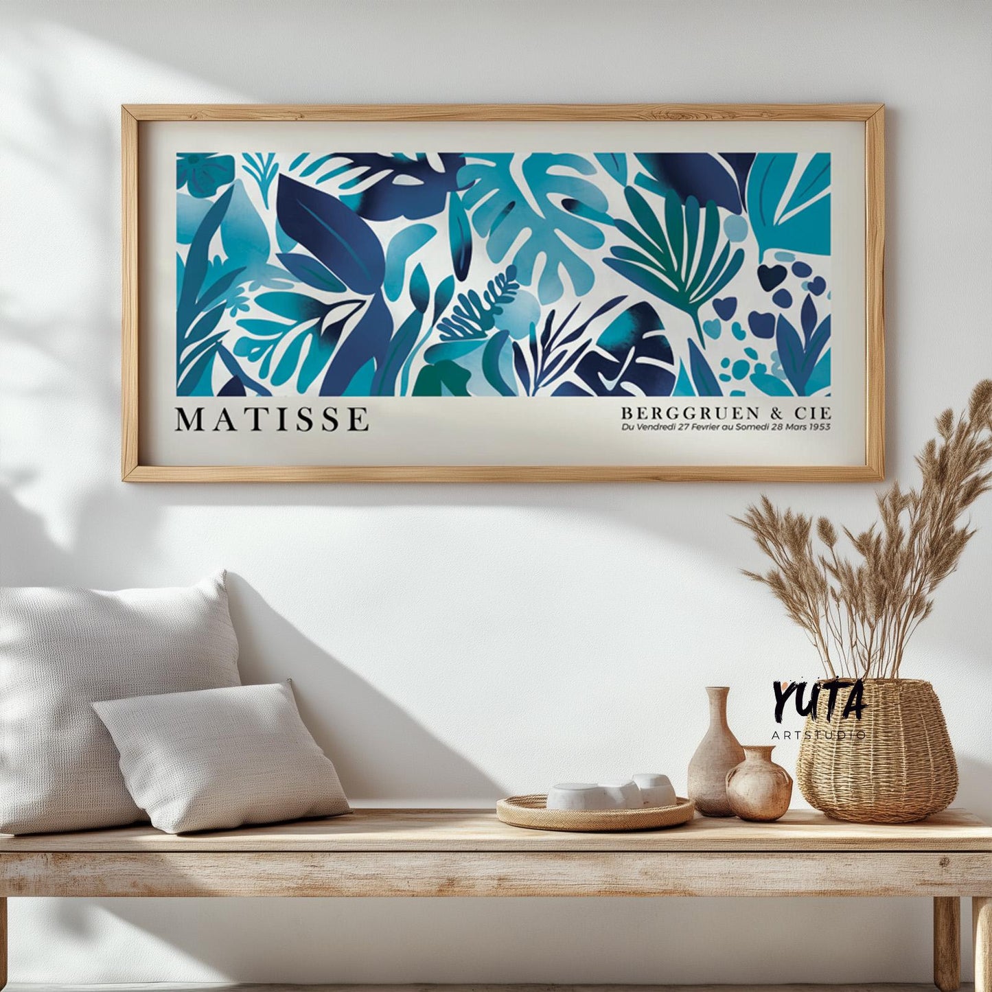 Blue tropical leaves artwork in Matisse style, framed and hung above a wooden bench