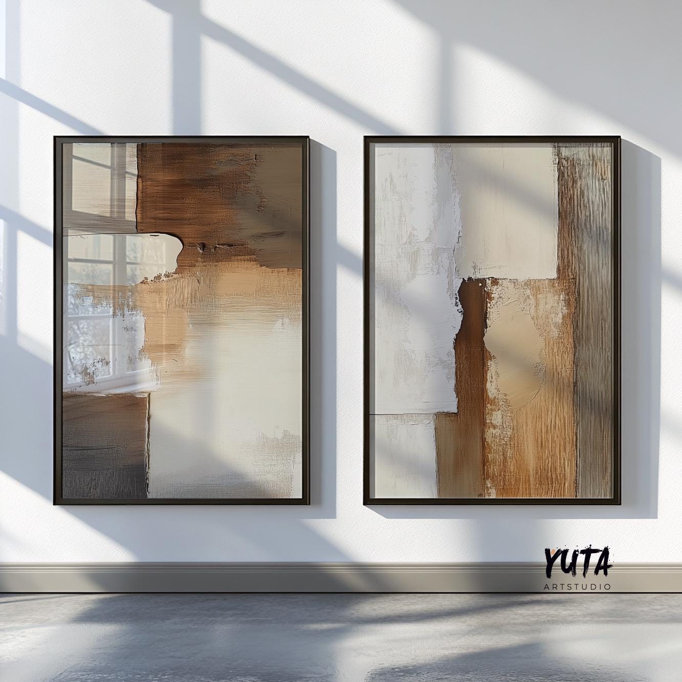 Pair of framed neutral abstract prints in beige and brown, displayed on a sunlit wall