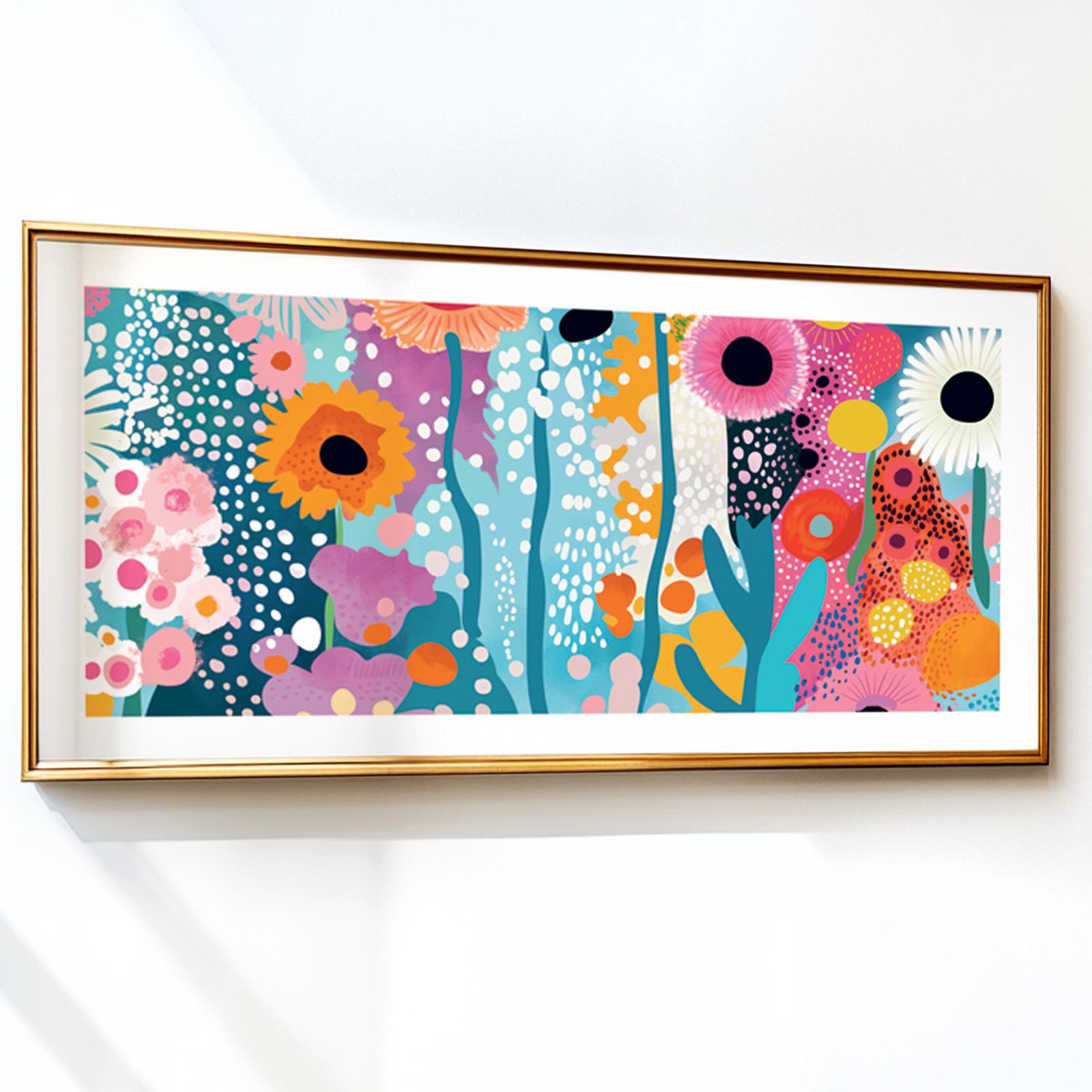 Abstract floral artwork with bold, colorful flowers in a gold frame on a white wall