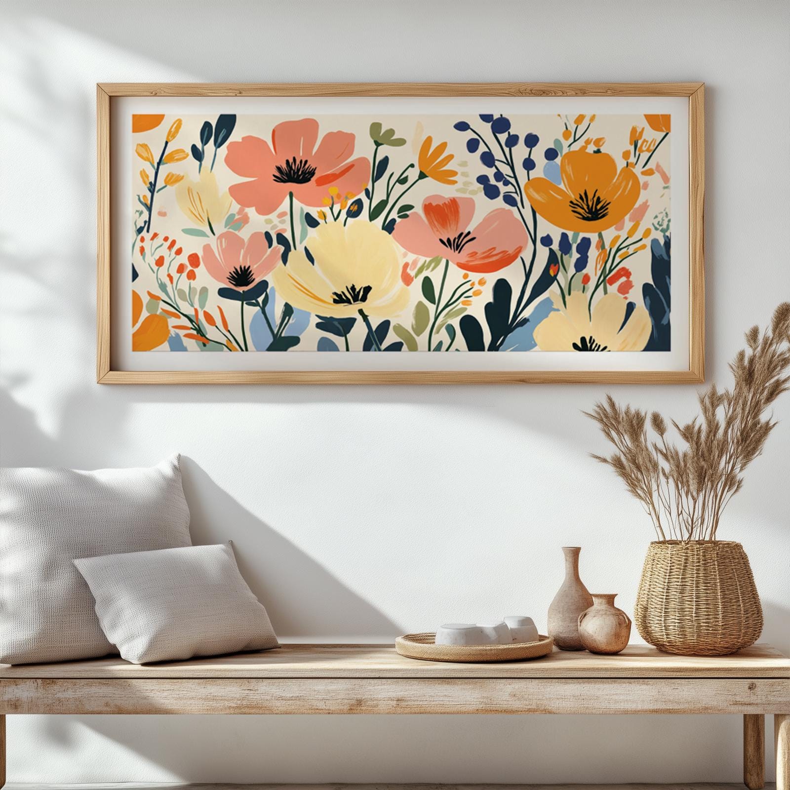 Panoramic floral artwork in a light wood frame displayed above a cushioned bench.