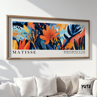 Framed tropical floral artwork hung above a white sofa, shown before packaging for shipping