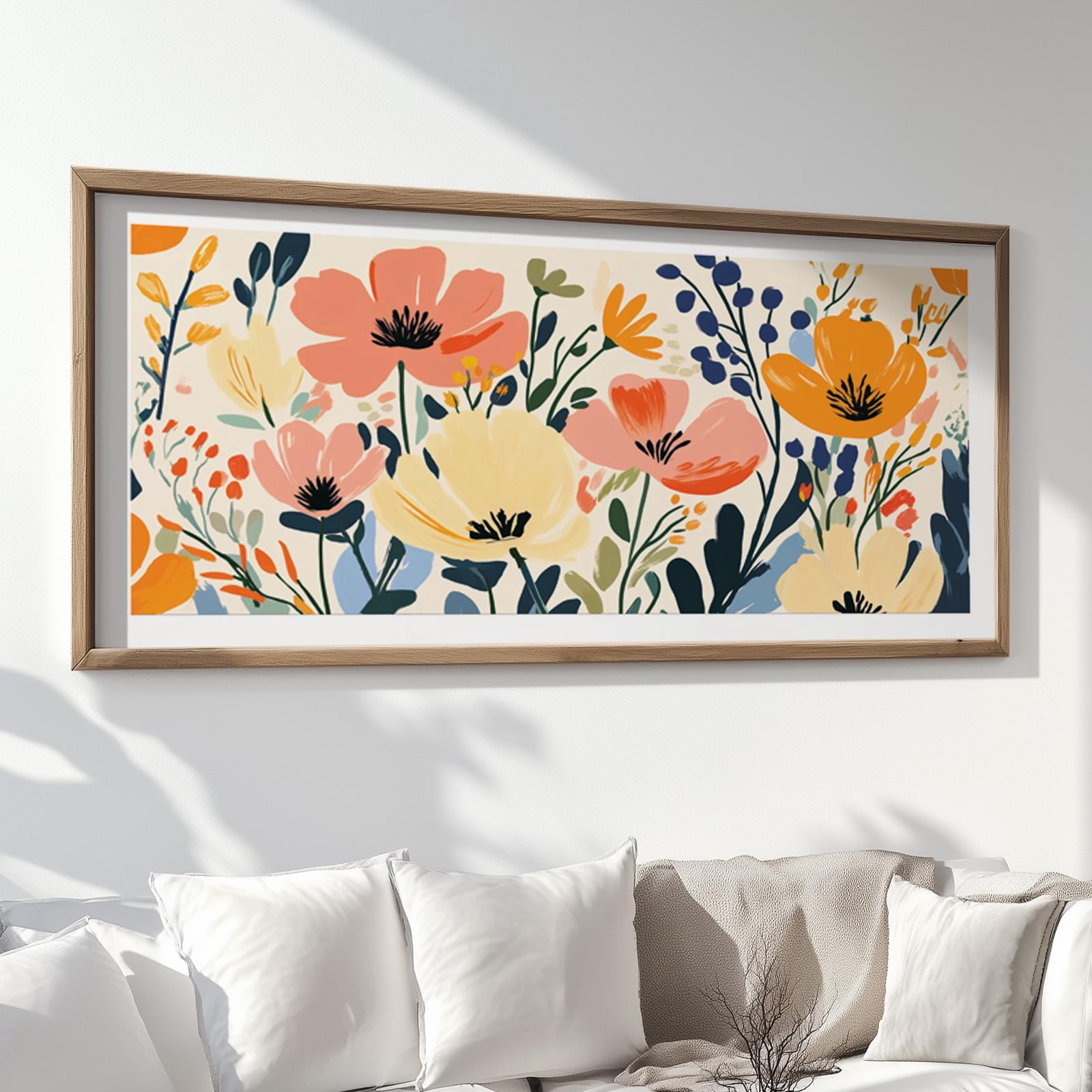 Floral abstract artwork in vibrant tones, framed in wood and hung above white cushions