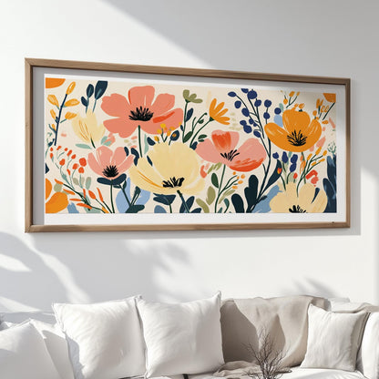 Floral abstract artwork in vibrant tones, framed in wood and hung above white cushions