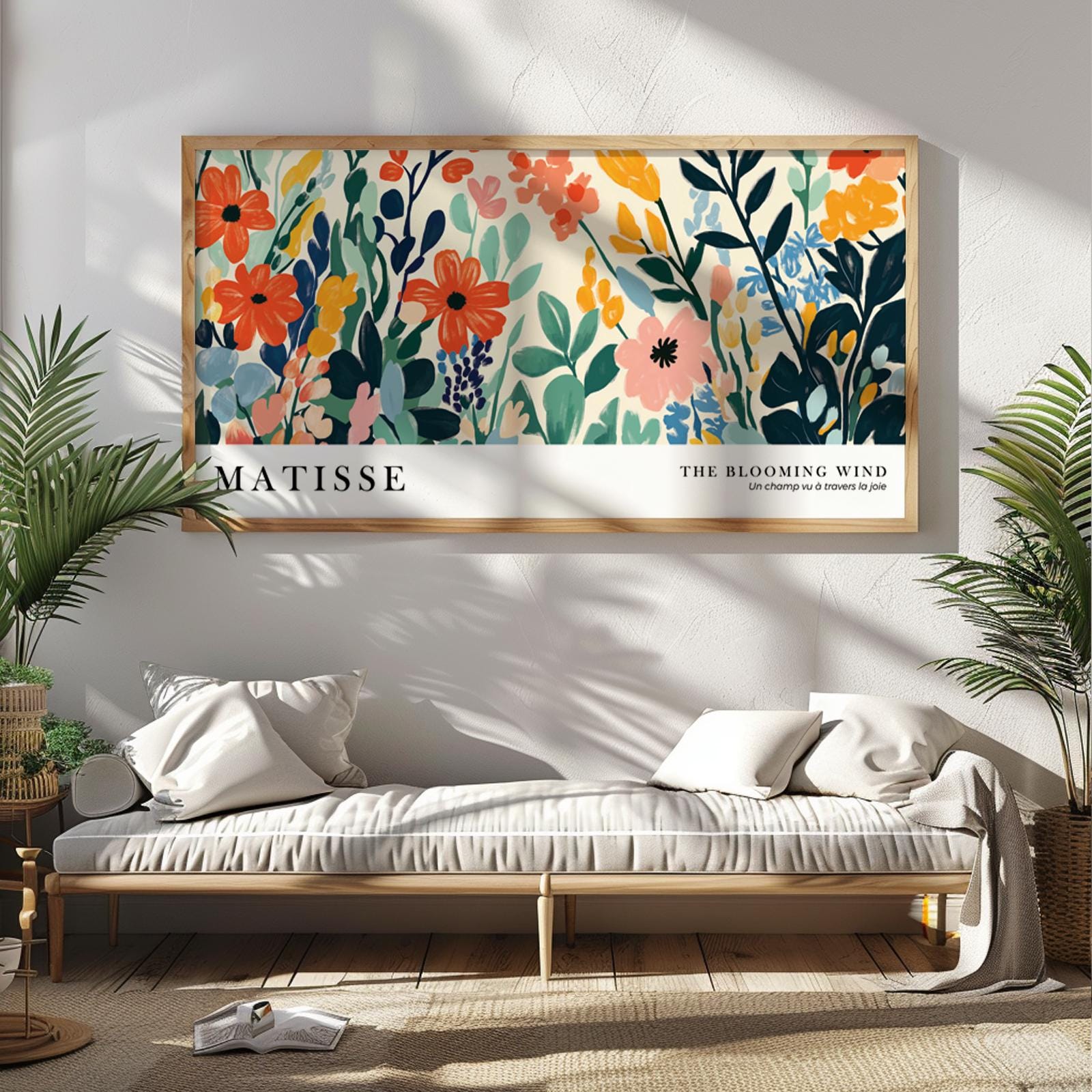 Colorful floral Matisse-style print in wide wood frame hung above a neutral bench sofa