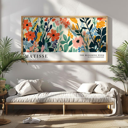 Colorful floral Matisse-style print in wide wood frame hung above a neutral bench sofa