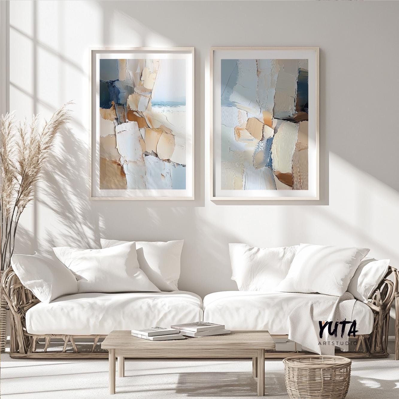 Neutral abstract diptych in light wood frames arranged above white seating area
