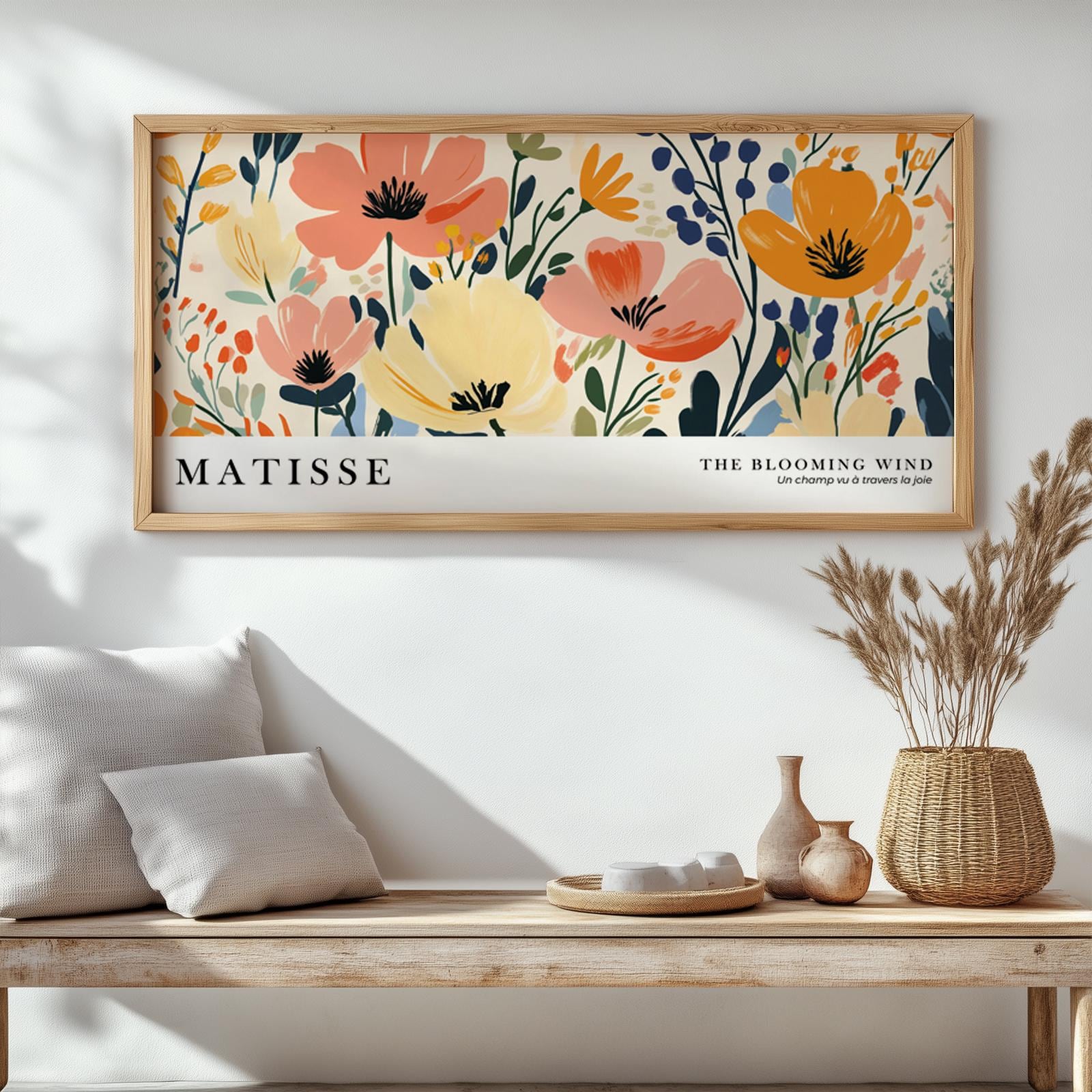 Framed Matisse-inspired floral poster above a wooden bench with ceramics, books, and dried grasses.