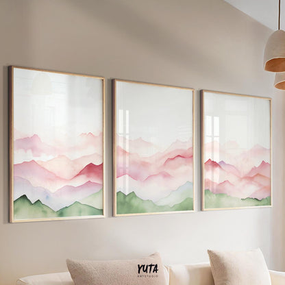 Watercolor mountain triptych in sage green and blush pink, framed and hung above a sofa