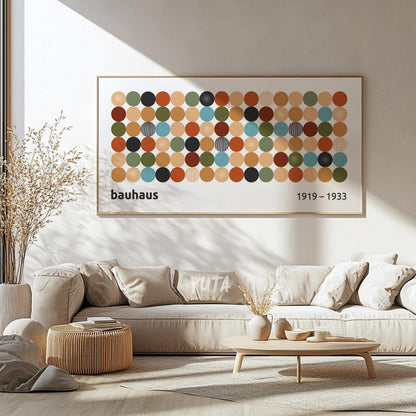 Colorful geometric Bauhaus print in a light wood frame displayed above a beige sofa