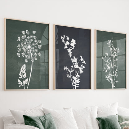 Green botanical wall art set of 3 featuring wildflower silhouettes on deep forest green and charcoal backgrounds