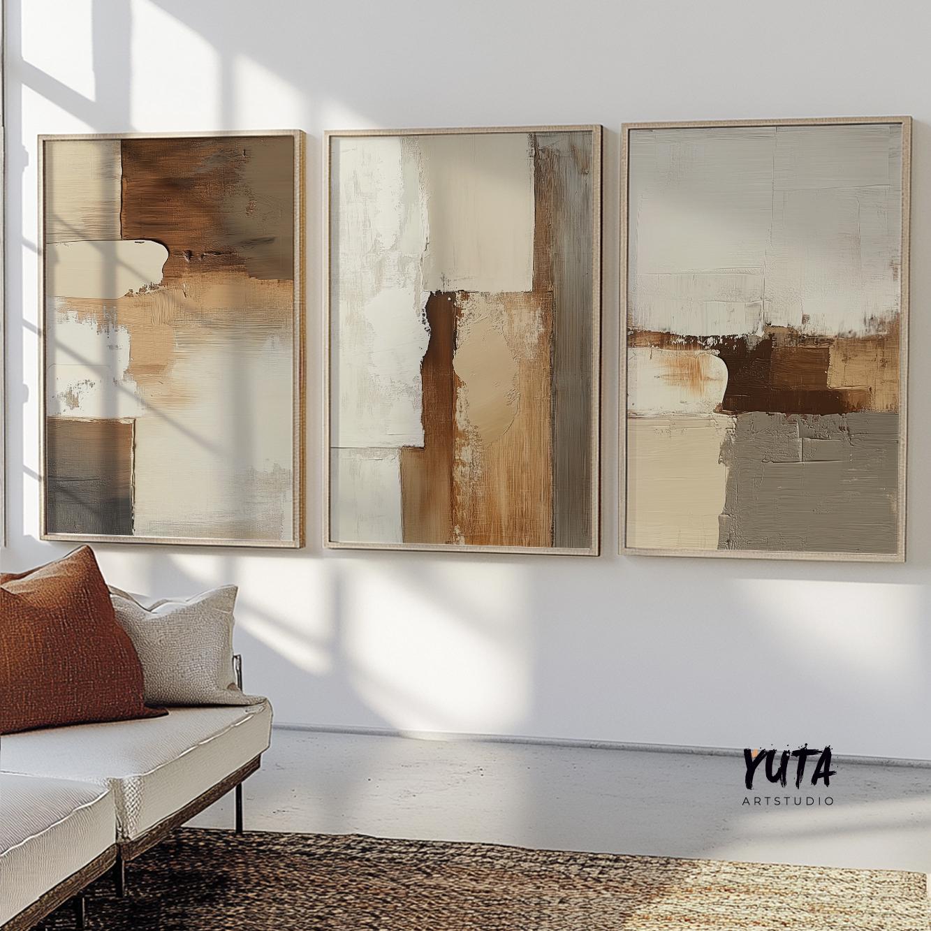 Three-piece neutral abstract wall art set in wood frames, sunlit above a cream sofa
