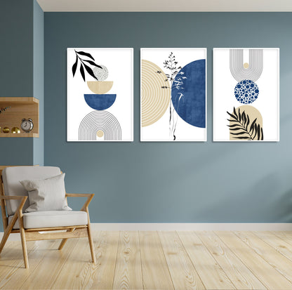 Trio of framed navy and beige geometric prints displayed above a light accent chair.