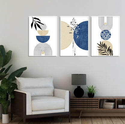 Three navy and beige geometric art prints with abstract botanical motifs framed above a wood console