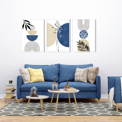 Trio of framed navy and beige geometric prints arranged above a blue sofa in daylight