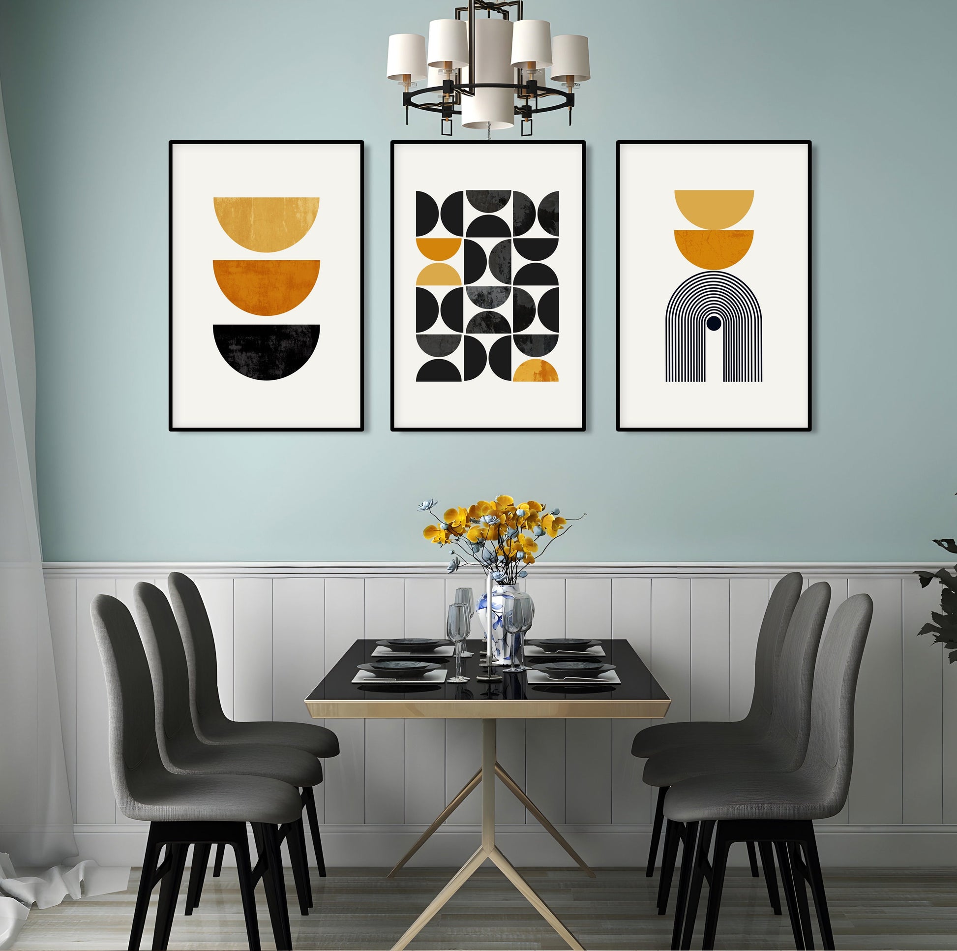 Three framed mustard yellow and black geometric prints above a dining table with flowers