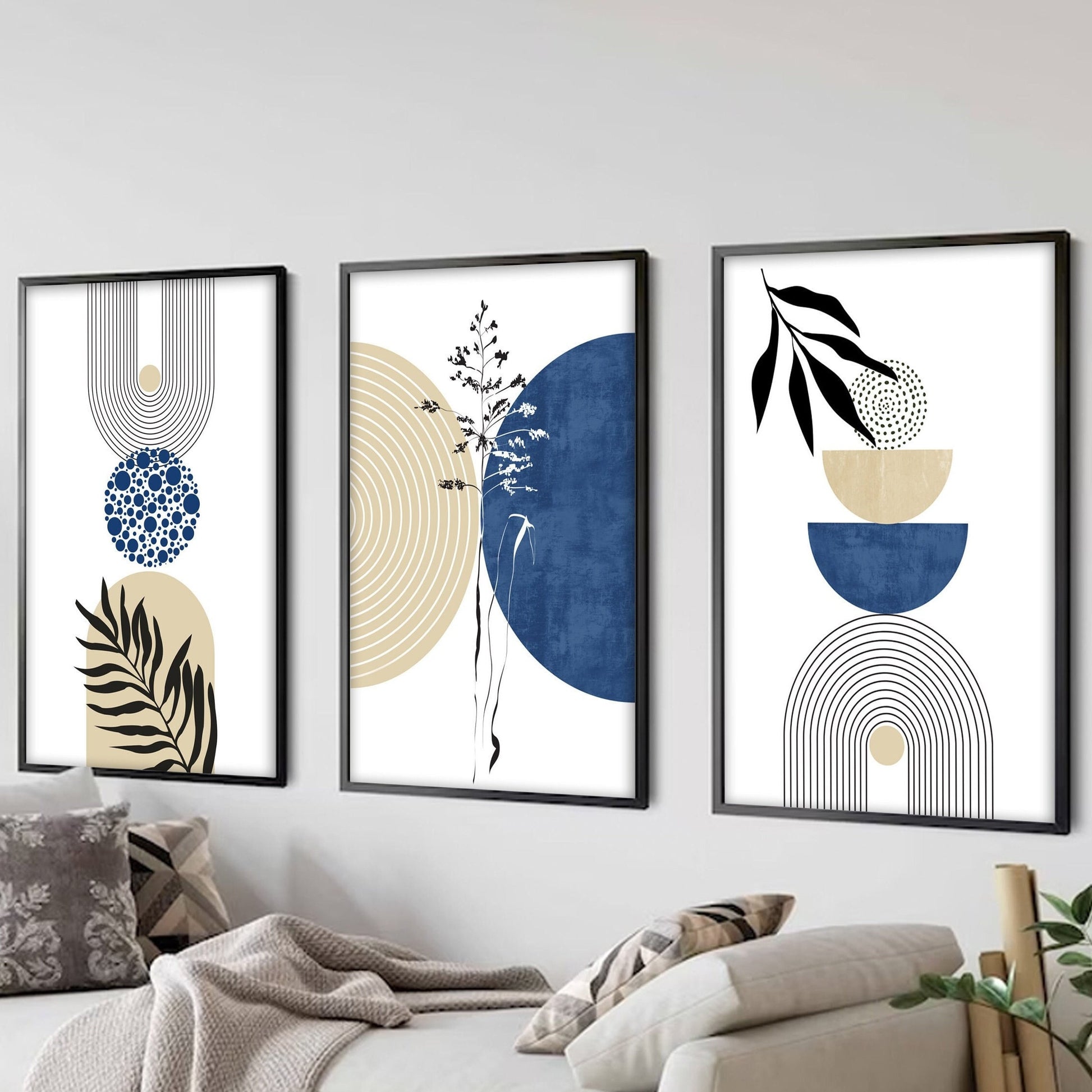 Geometric navy and beige wall art set with abstract botanical shapes in black frames above a sofa