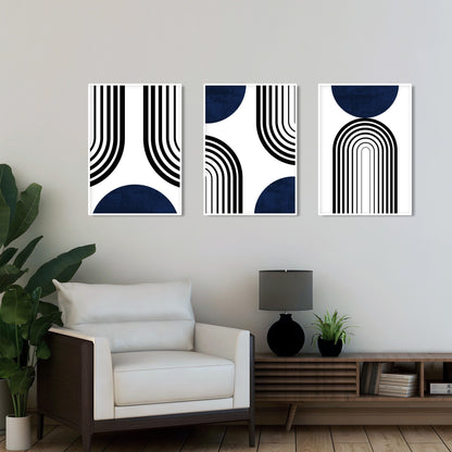 Three framed abstract navy blue and black prints hung above a modern white armchair