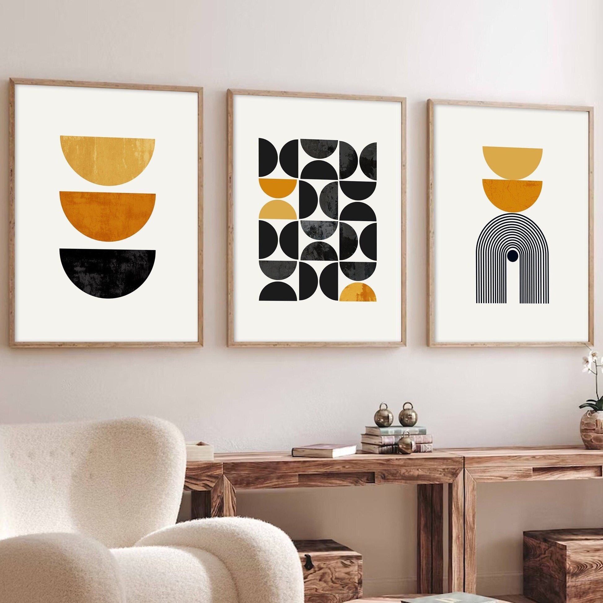 Trio of framed mid century geometric prints with mustard and black shapes above a wood console