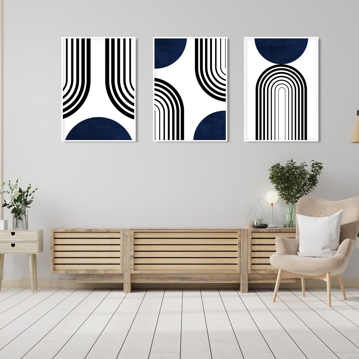 Three framed abstract navy and black prints arranged above a console with plants and ceramics